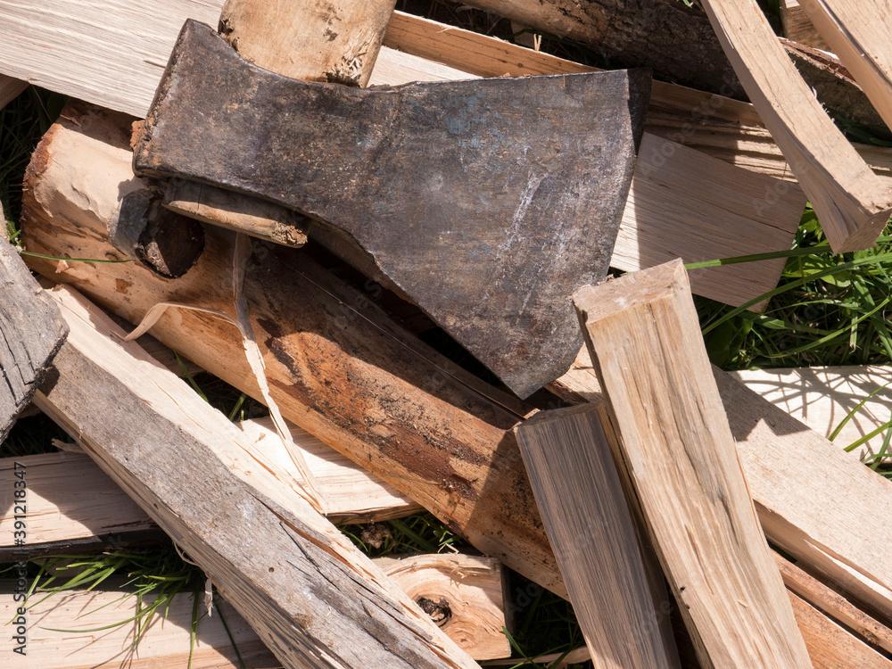 Fresh bundle of wooden firewood slivers and old iron axe with wooden handle on green grass top view Fresh bundle of wooden firewood slivers and old iron axe with wooden handle on green grass top view