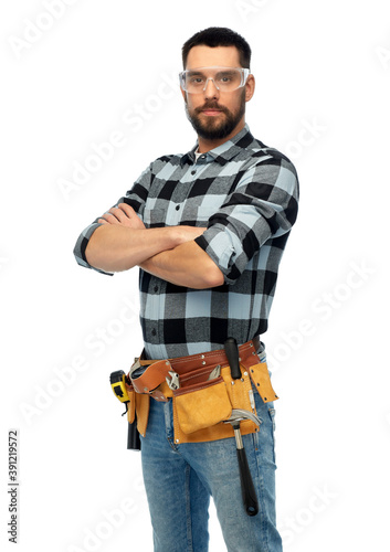 profession, construction and building - happy smiling male worker or builder in goggles with crossed arms over white background