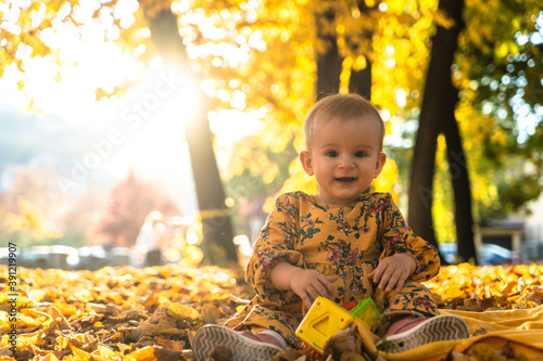 happy little baby girl laughing and playing in the autumn on the nature walk outdoors