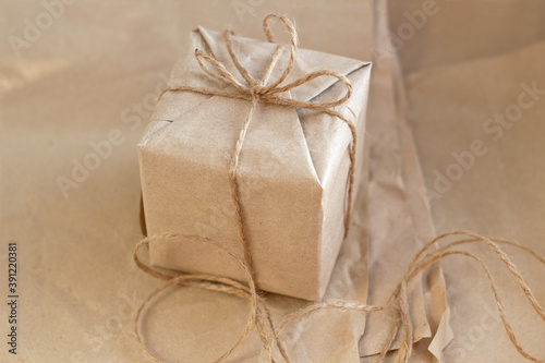 Gift box packed in kraft paper and tied with a tourniquet, ecological packaging, recycled paper, zero waste, close up