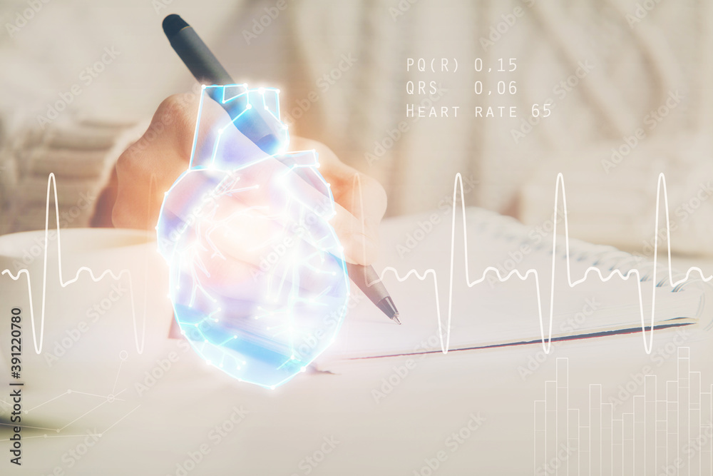 Heart hologram over woman's hands writing background. Concept of Medical study. Multi exposure Heart hologram over woman's hands writing background. Concept of Medical study. Multi exposure