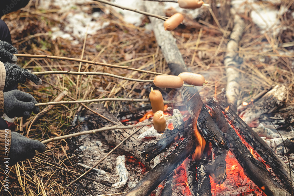 Camping in the wild. BBQ sausages on the fire. Picnic in the wild forest concept.