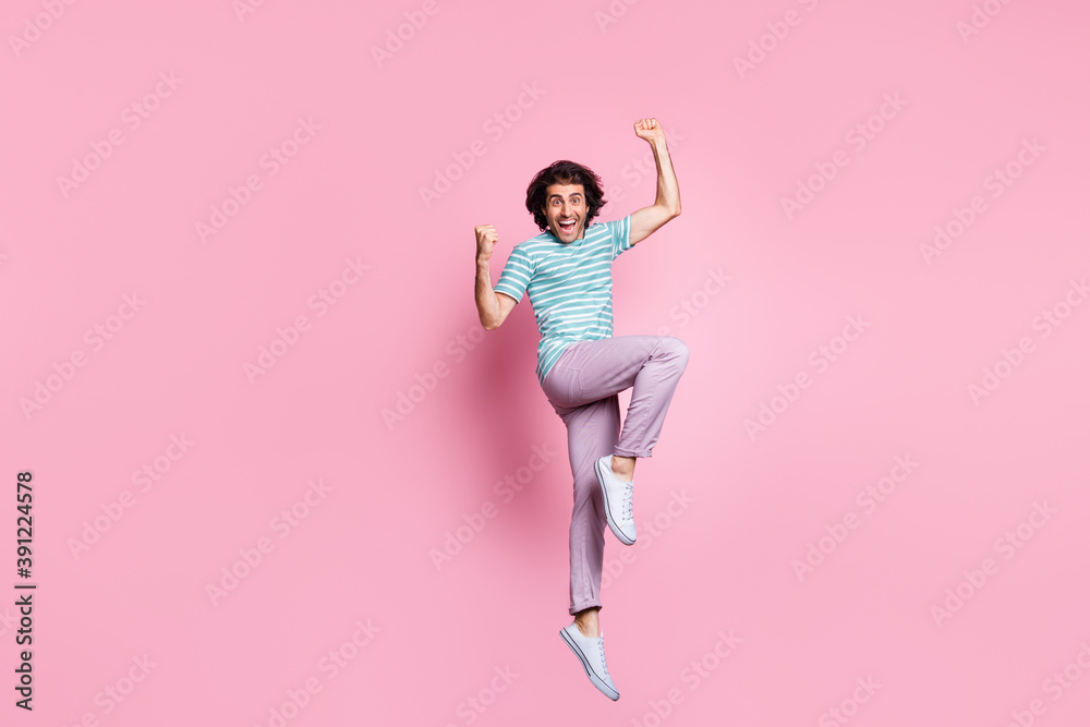 Full length photo of lucky young guy dressed casual clothes jumping hands arms fists isolated color background