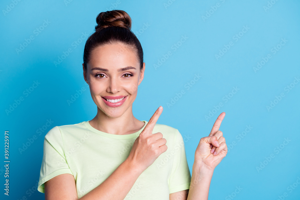 Photo of positive lady point index finger empty space isolated over blue color background Photo of positive lady point index finger empty space isolated over blue color background