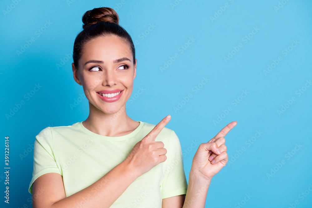 Photo of positive lady point index finger empty space for ads promotion isolated over blue pastel color background Photo of positive lady point index finger empty space for ads promotion isolated over blue pastel color background