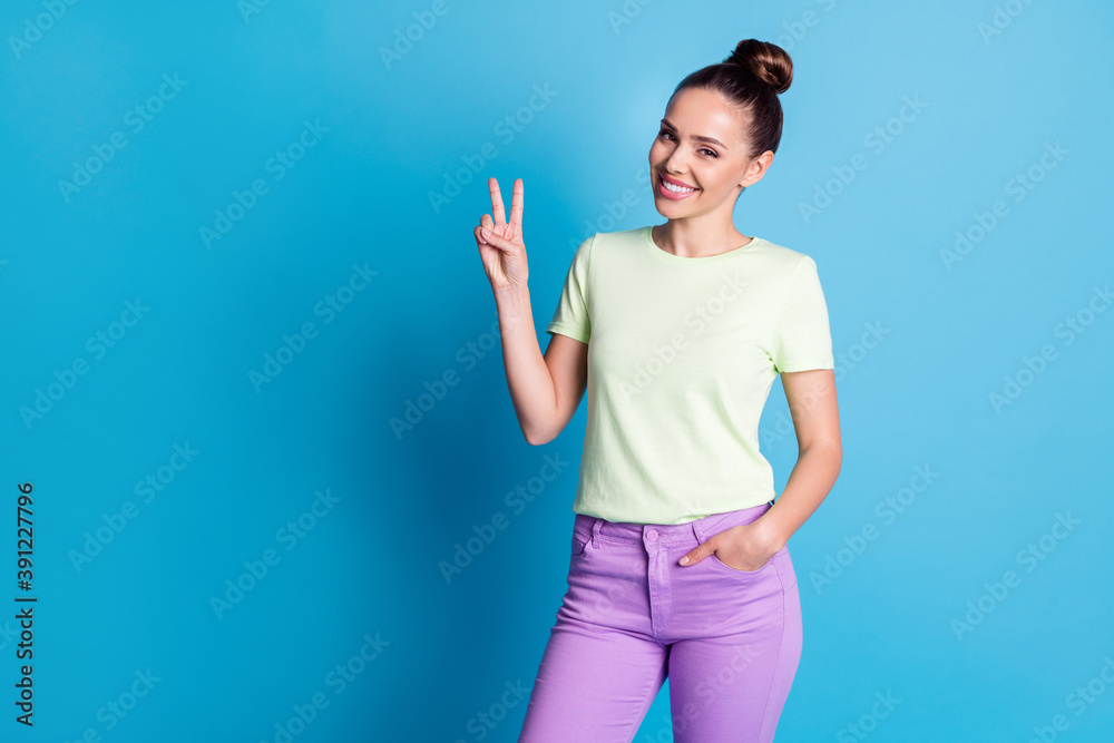Fototapeta premium Portrait of her she nice attractive lovely charming cheerful cheery girl wearing comfortable clothes showing v-sign isolated over bright vivid shine vibrant blue color background