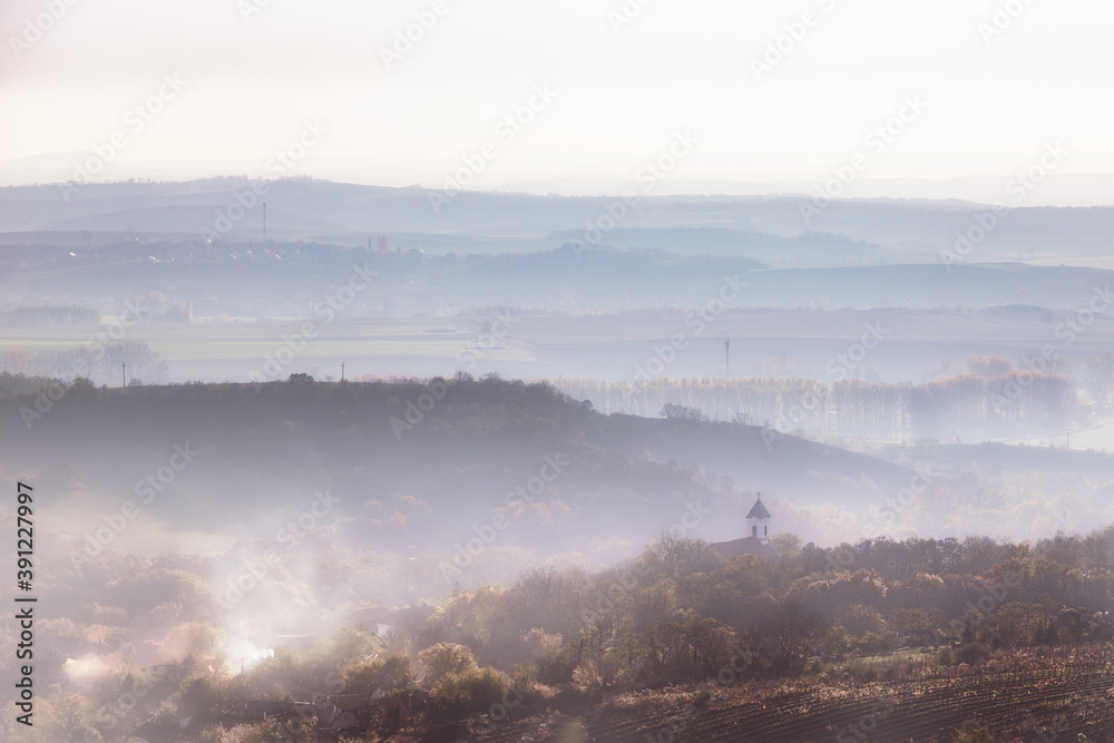 Nebel im Tal, ein Kirchturm ragt empor