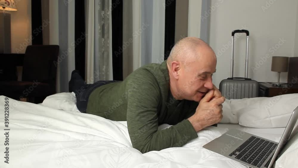 middle-aged man in typing text on laptop keyboard, surfing the internet in apartments, hotel room, concept of business travel, tourism, remote work middle-aged man in typing text on laptop keyboard, surfing the internet in apartments, hotel room, concept of business travel, tourism, remote work
