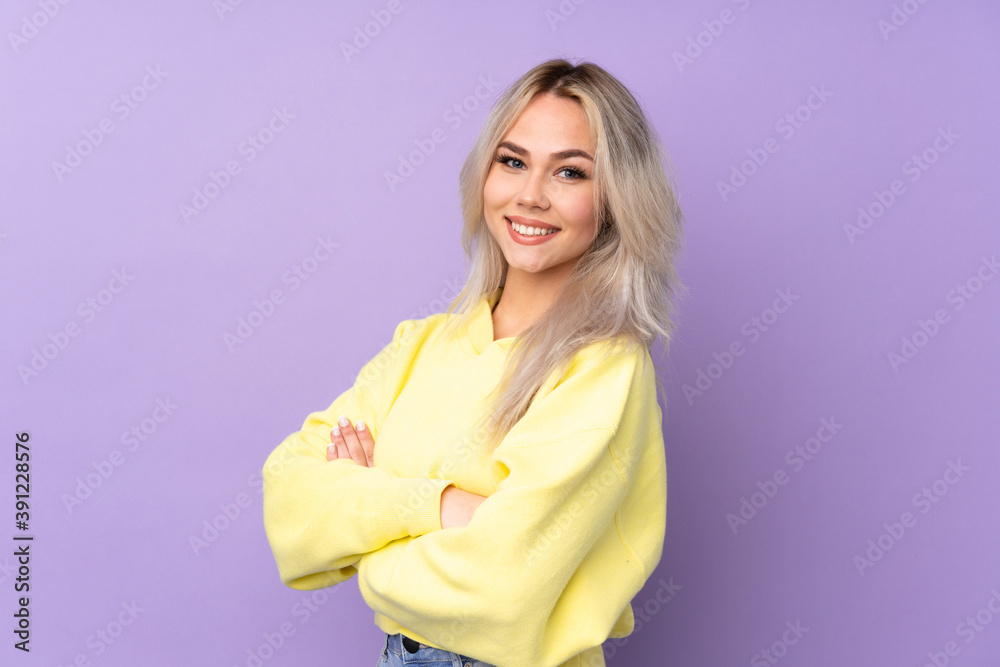 Teenager girl wearing a yellow sweatshirt over isolated purple background with arms crossed and looking forward Teenager girl wearing a yellow sweatshirt over isolated purple background with arms crossed and looking forward