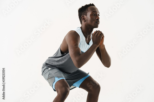 Young african american sportsman doing exercise while working out