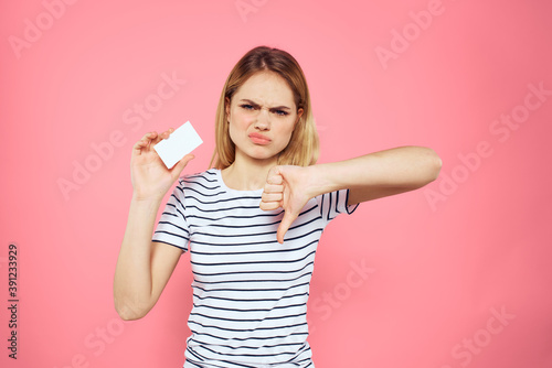 Woman with a business card in her hands a striped T-shirt pink background Copy Space advertising © SHOTPRIME STUDIO