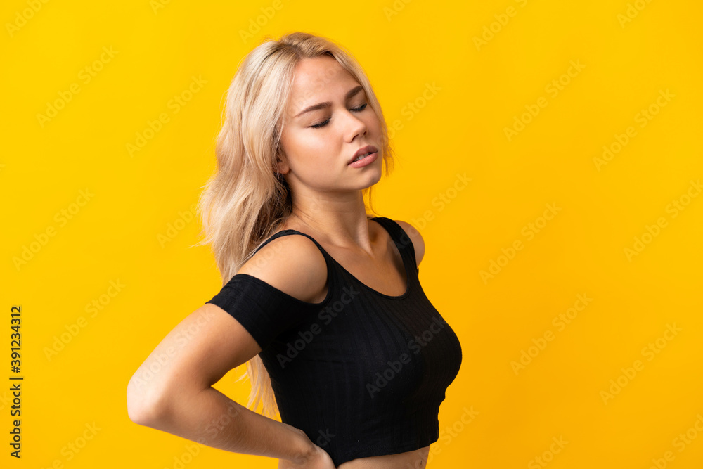 Fototapeta premium Young Russian woman isolated on yellow background suffering from backache for having made an effort
