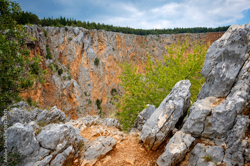 rocky wall leading to the deep hole, big stones, croatia