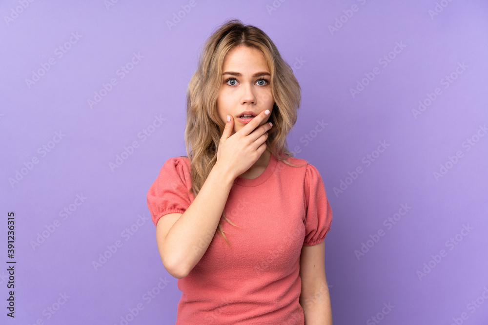 Teenager Russian girl isolated on purple background surprised and shocked while looking right Teenager Russian girl isolated on purple background surprised and shocked while looking right