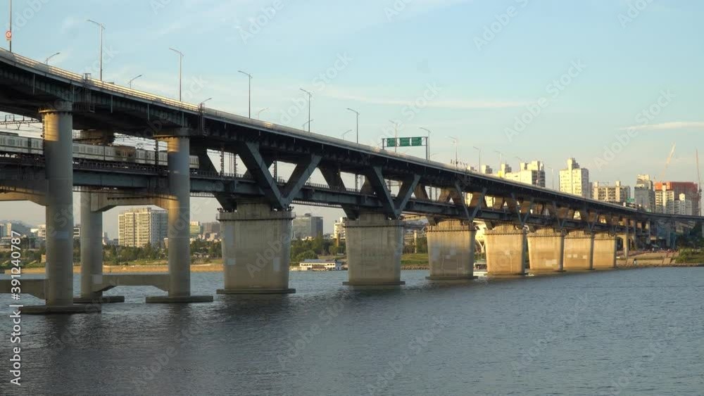 Subway train crossing Cheongdam Bridge over Han river In Seoul, South Korea - static wide-angle shot Subway train crossing Cheongdam Bridge over Han river In Seoul, South Korea - static wide-angle shot