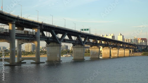 Subway train crossing Cheongdam Bridge over Han river In Seoul, South Korea - static wide-angle shot photo