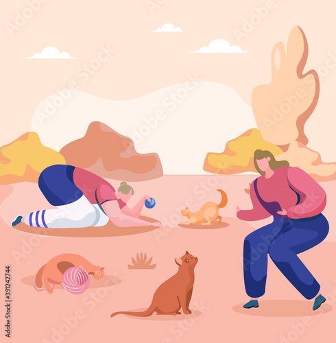One young woman is playing with the red cat and taming it, while other is using ball of thread to play with a kitten. A cat without an owner lies near a ball of thread. Walk with pets in the park