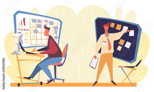 One young man working at laptop and looking at the panel with stickers and assignments while another man peels one paper off the board. Working day in business office with yellow leaves on background