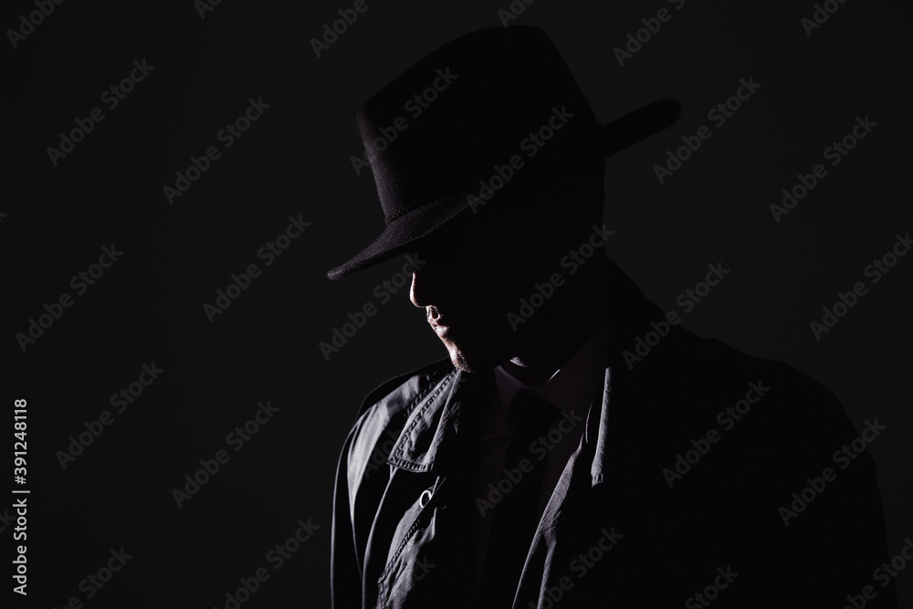 Old fashioned detective in hat on dark background Old fashioned detective in hat on dark background