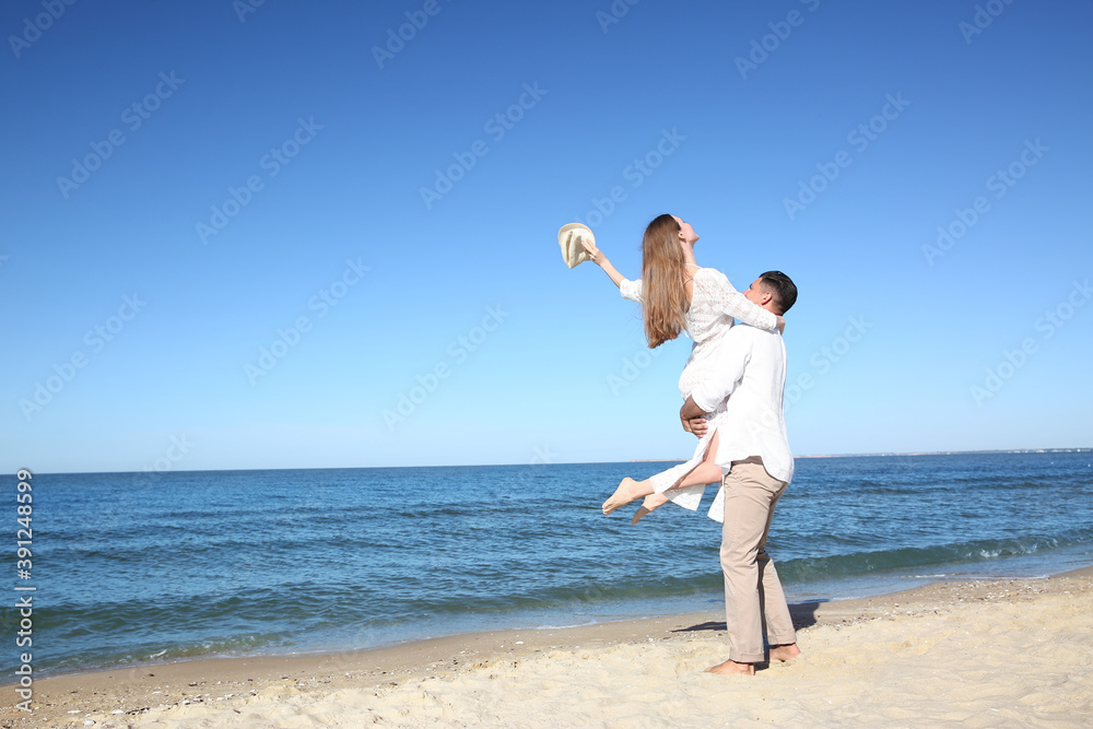 Lovely couple having fun on sea beach. Space for text Lovely couple having fun on sea beach. Space for text