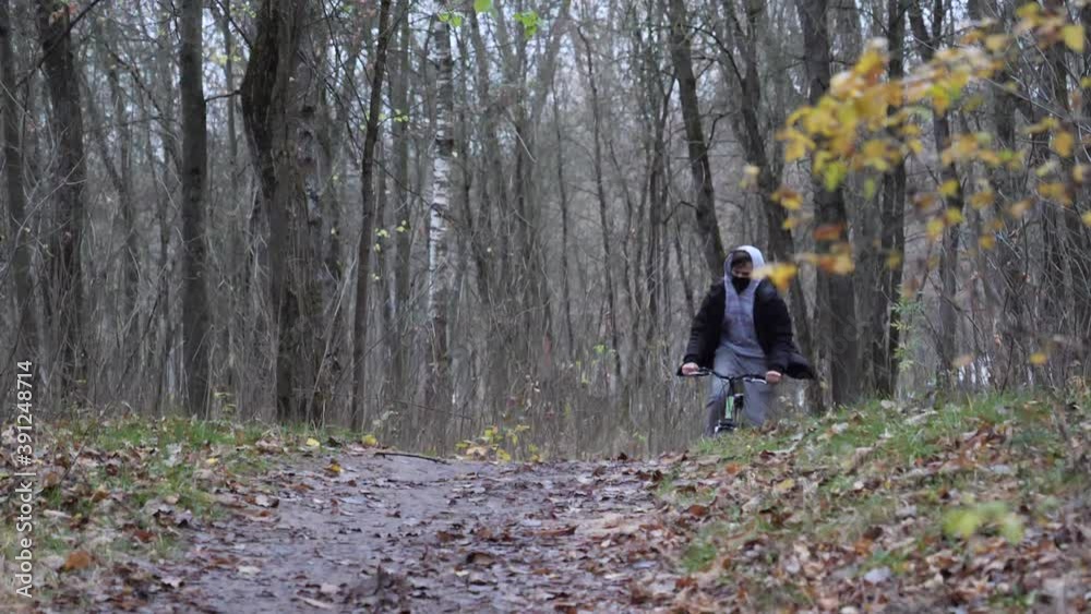cyclist teenager rides the path in the park in autumn cyclist teenager rides the path in the park in autumn