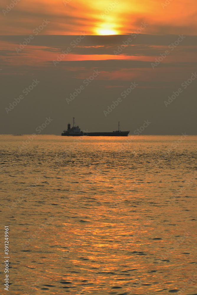 夕日に染まる海と船