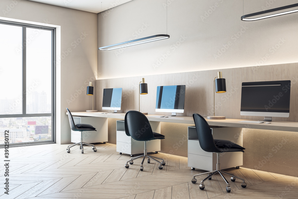 Modern coworking office interior with equipment and computers on desktop Modern coworking office interior with equipment and computers on desktop