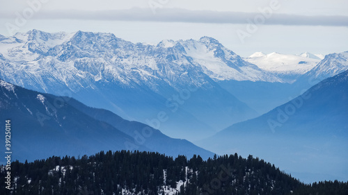 Snow-capped mountain ranges in BC, Canada, bathed in blue light (early winter).