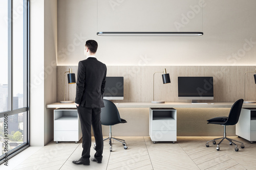 Businessman standing in modern coworking office interior © Who is Danny