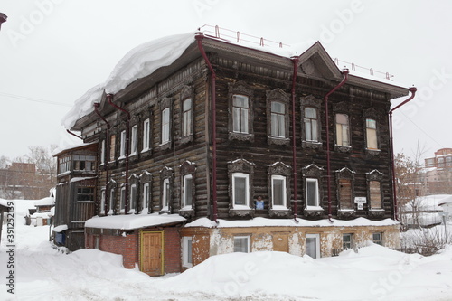 Vintage wooden house with carved windows on Tatarskaya Street, 42a, Tomsk city, Russia. Art nouveau style in architecture. Snowy winter. Tomsk monument, landmark, sight photo