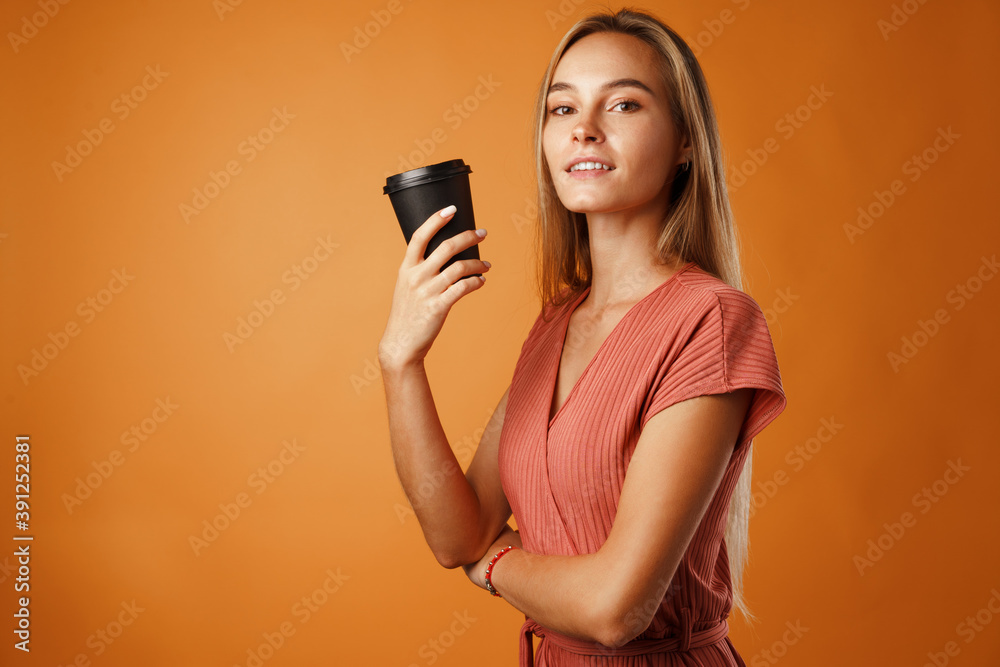 Obraz premium Attractive young woman standing and drinking hot drink