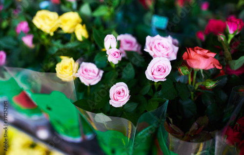 Beautiful bouquets of pink and yellow roses in a flower shop. A bright mix of flowers. Handsome fresh bouquets. Flowers delivery. Floral shop concept .