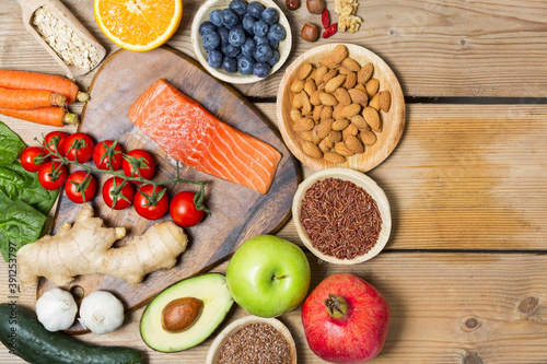  Healthy food, clean eating selection: fruit, vegetable, seeds, superfood, cereals, leaf vegetable on wooden background copy space.