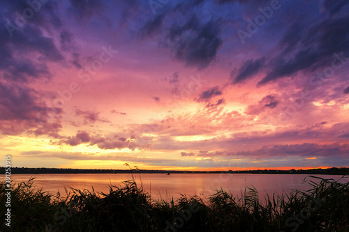 Beautiful sunrise on the lake, with reeds in the foreground