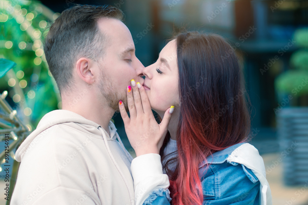Naklejka premium Stylish caucasian couple in love hugging each other while standing outdoors on the street. Love, relationships, romance, carefree and happiness concept. Copy space.