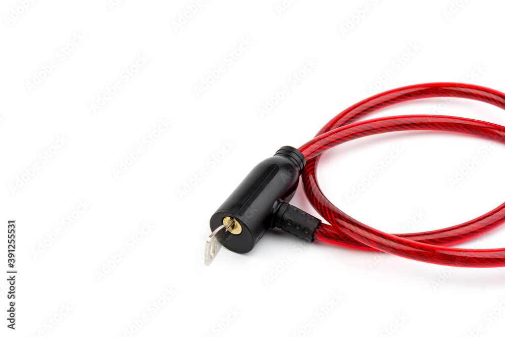 Flexible red bicycle cable with key on white background. Security and safety concept. Flexible red bicycle cable with key on white background. Security and safety concept.