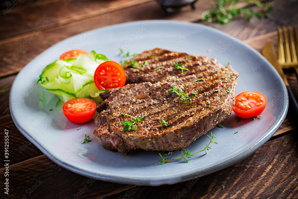 Grilled juicy steak medium rare beef with spices and fresh salad.