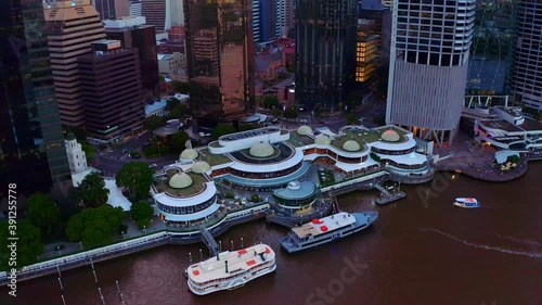 CityCat Arriving And Leaving Eagle Street Pier Ferry Terminal At Brisbane Central Business District In Queensland, Australia. - aerial drone shot photo