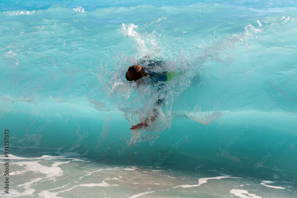 Teenager having great fun with big waves in the sea