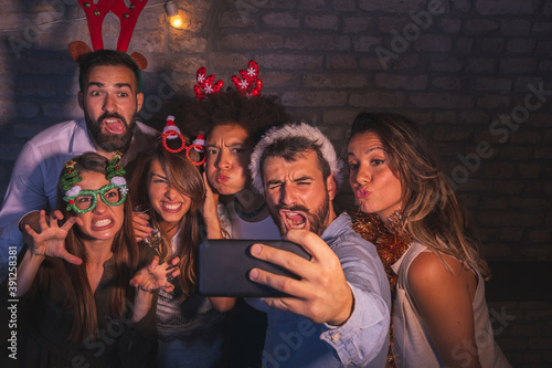 Group of friends taking crazy selfies at New Year's Eve party