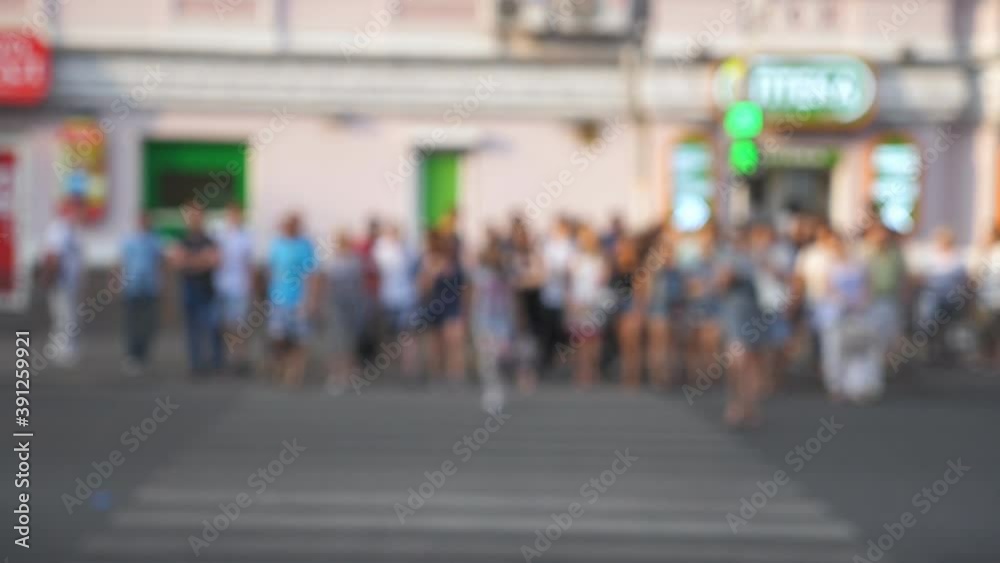 Unrecognizable pedestrians crossing intersection in big city at summer day. Crowd of people walking a crosswalk in downtown. Concept of busy urban lifestyle. Blurred motion. Close up Slow motion Unrecognizable pedestrians crossing intersection in big city at summer day. Crowd of people walking a crosswalk in downtown. Concept of busy urban lifestyle. Blurred motion. Close up Slow motion