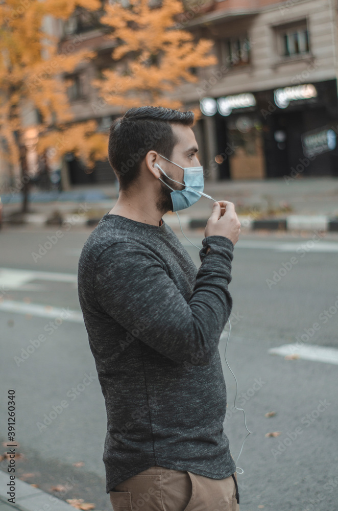 hombre con mascarilla hablando por teléfono en la calle hombre con mascarilla hablando por teléfono en la calle