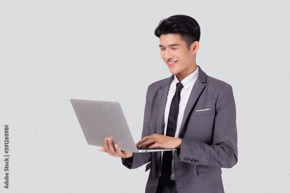 Young asian business man standing work on laptop computer to internet online isolated on white background, businessman confident and notebook, freelance with success, marketing and communication. Young asian business man standing work on laptop computer to internet online isolated on white background, businessman confident and notebook, freelance with success, marketing and communication.