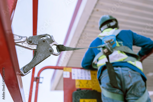 Worker on a Scissor Lift Platform working at site focus on full harness safety belt photo