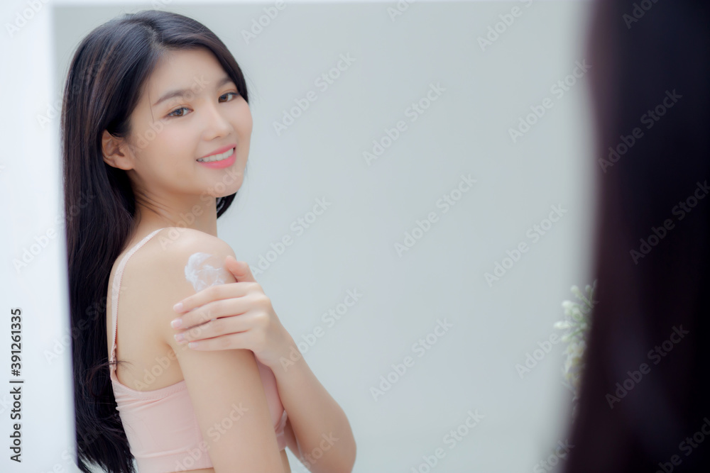 Beautiful sexy young asian woman look mirror applying cream on shoulder and message, beauty girl applying body lotion skin care for health and soft hydration, treatment and cosmetic with moisturizer. Beautiful sexy young asian woman look mirror applying cream on shoulder and message, beauty girl applying body lotion skin care for health and soft hydration, treatment and cosmetic with moisturizer.