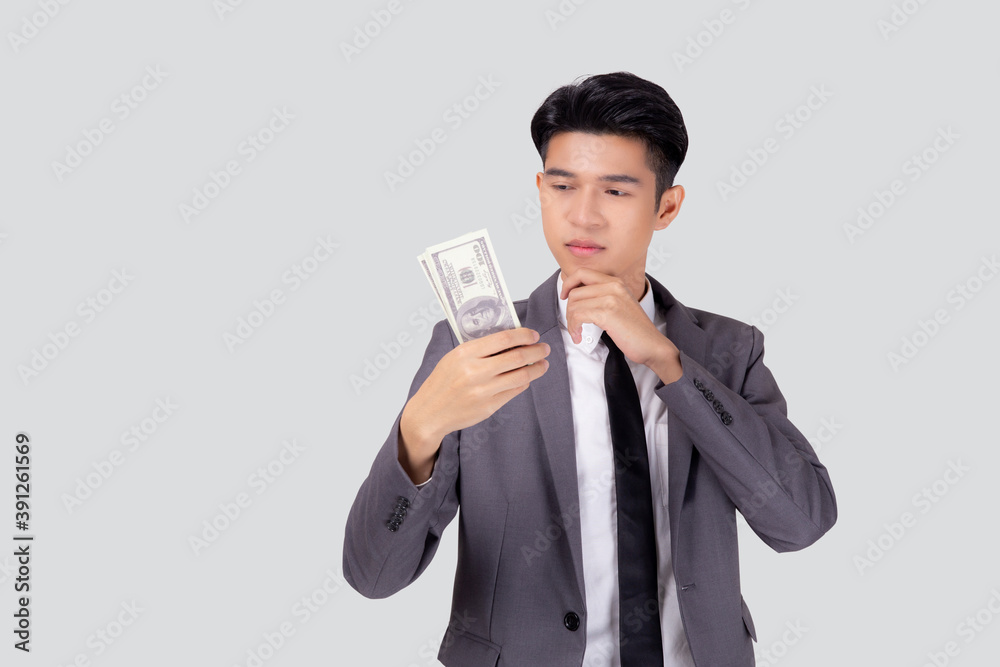 Young asian business man in suit holding dollar money isolated on white background, businessman think idea about finance for success, male holding cash with banknote and question, one person. Young asian business man in suit holding dollar money isolated on white background, businessman think idea about finance for success, male holding cash with banknote and question, one person.