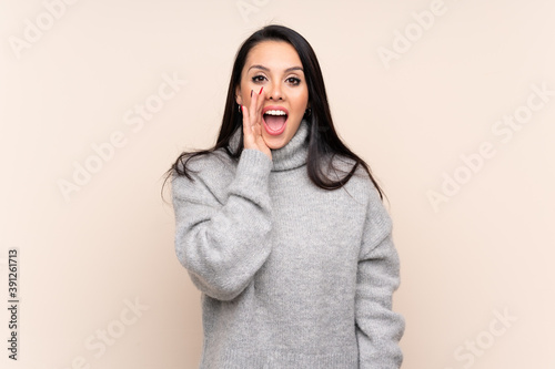 Young Colombian girl over isolated background shouting with mouth wide open © luismolinero