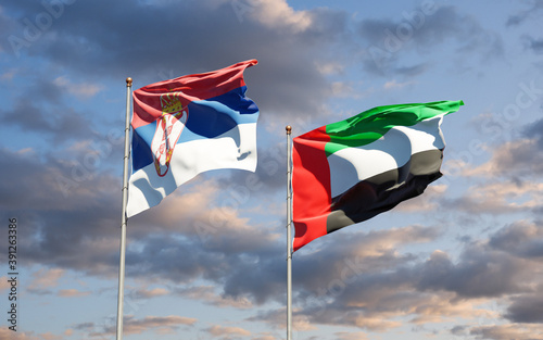 Beautiful national state flags of Serbia and UAE United Arab Emirates together at the sky background. 3D artwork concept.