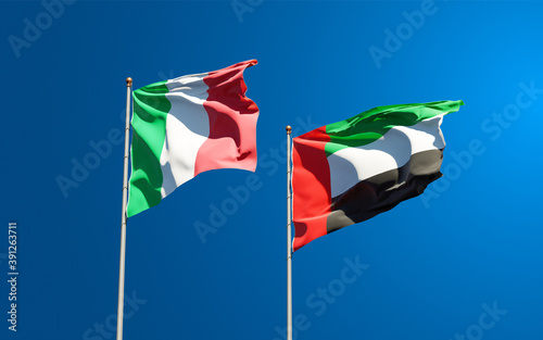 Beautiful national state flags of Italy and UAE United Arab Emirates together at the sky background. 3D artwork concept.