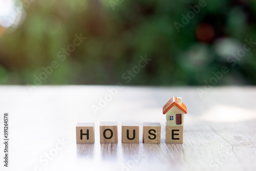 Orange house on a wooden block And the word house on a wooden block Planning ideas for real estate investments, home savings and buying, mortgages and borrowing, banking, accounting and taxes.